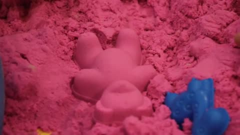 Pixel Kinaragendis plays with colorful kinetic sand / magic sand.