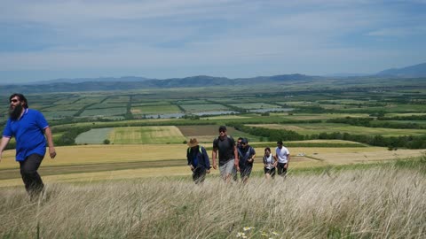 Group of tourists walk through beautiful landscape