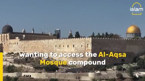 Muslims take part in Friday prayers as Israeli soldiers look on