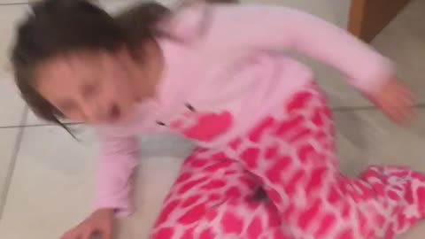 English girl in pink shirt runs across wet floor and slips in kitchen