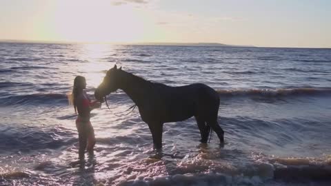 Young sexy woman dressed bikini rest with horse in the river water sunset