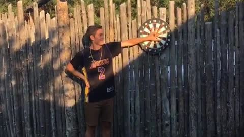 Red head man plays darts misses friends hand