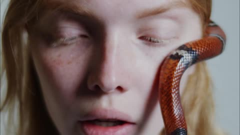 Woman Feeling Helpless On A Snake Crawling On Her Face