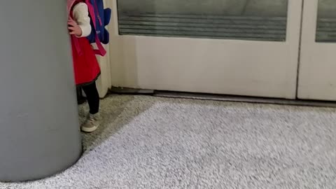 Adorable Toddler Is Playing Peek-a-boo At The Airport