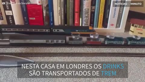 Trem de brinquedo transporta drinks da cozinha para o sofá