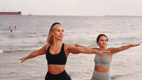 Beautiful women performing yoga at the beach during summer vacation