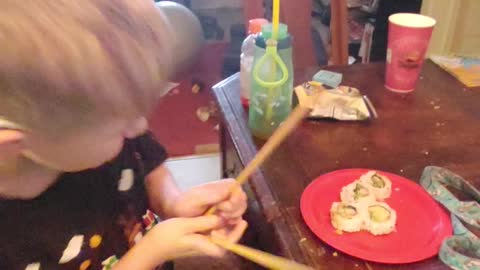 Henry eats sushi with chopsticks