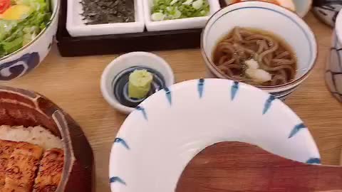 Rice topped with eel, salad, and noodles. Best food ever.