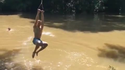 Teen in blue shorts has trouble on rope swing