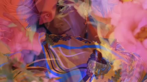 Extravagant gay boy in abstract video with flowers