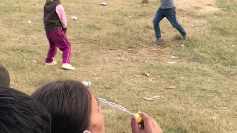 Cute Nepalese Girl Playing with Air Bubbles