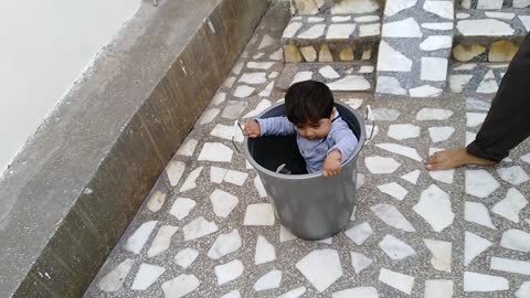 Cute kid went in bucket and came down through slide with bucket