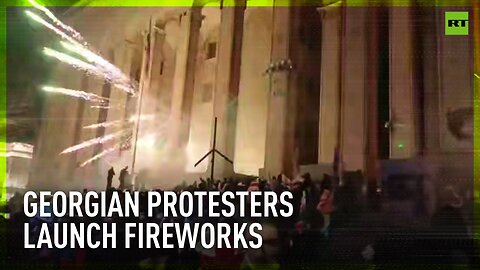 Georgian Parliament building lit up with fireworks set off by pro-EU protesters