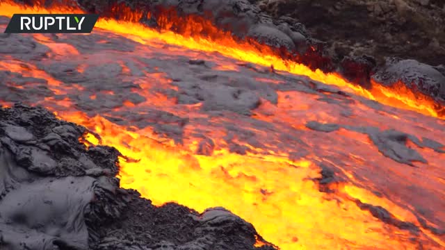 Iceland’s Fagradalsfjall volcano’s lava overflows a dam to reach a valley downhill