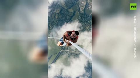 Russian daredevil climbs rope tied to airborne aircraft