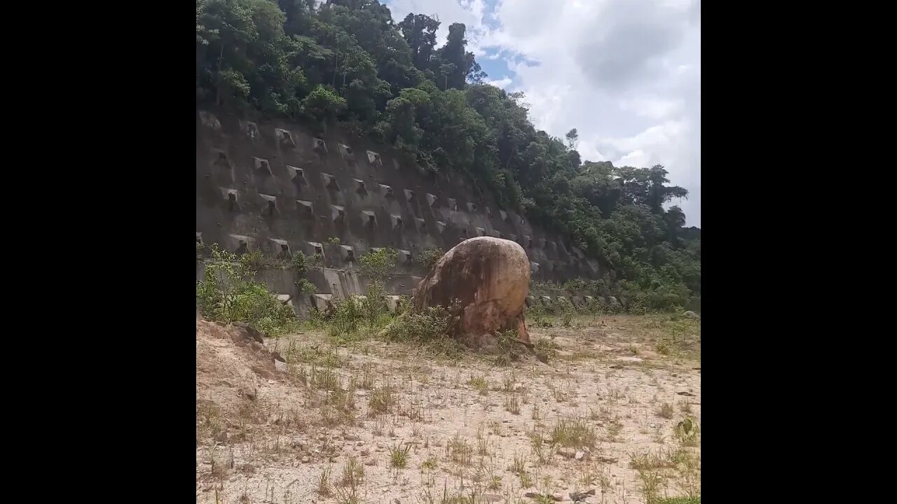 TRECHO DO ESQUELETO DO RODOANEL NORTE TRILHA CERCADA DE MATO E RESTOS DE OBRA E PEDRAS GRANDES