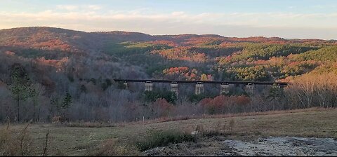 Train on trestle with Colorful Fall Mountain Foliage in Background