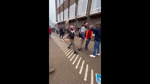 Dutch police stand by and do nothing while protesters beat them with sticks