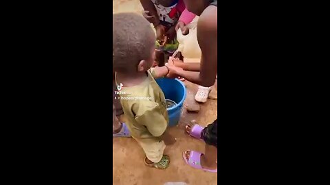 Little boy kneels to thank the women giving him food and god