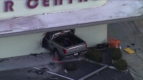 Truck crashes into Lakeland building, partially shutting down road