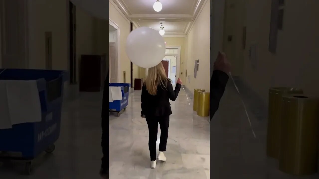 Majorie Taylor Greene carries white balloon around Capitol