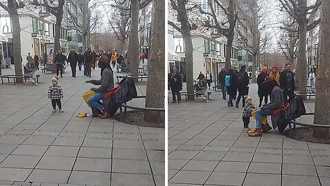 Toddler grooves to the beat of street drummer's performance