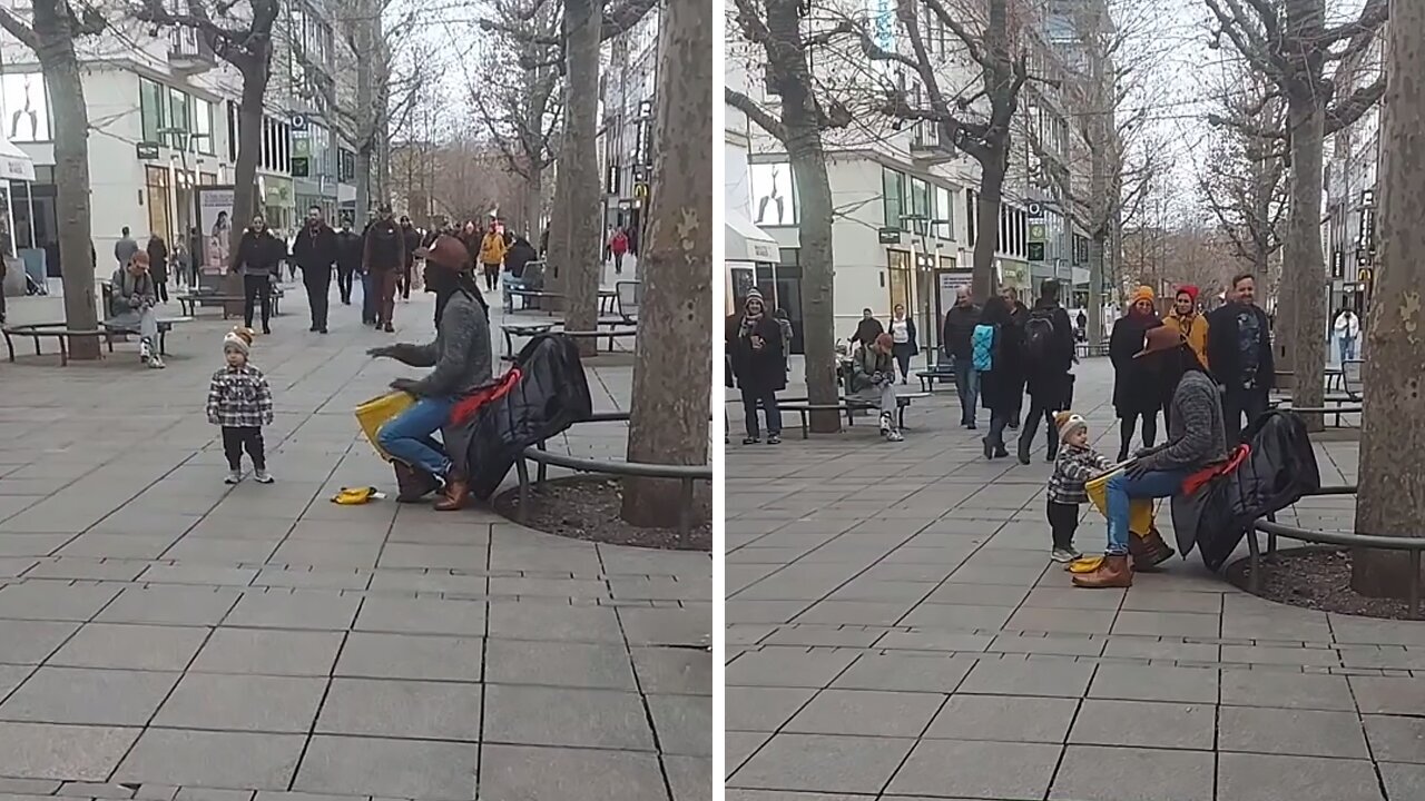 Toddler grooves to the beat of street drummer's performance