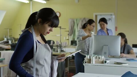 medium shot of young hispanic woman using tablet computer when working at sewing fa SBV 327453536 HD