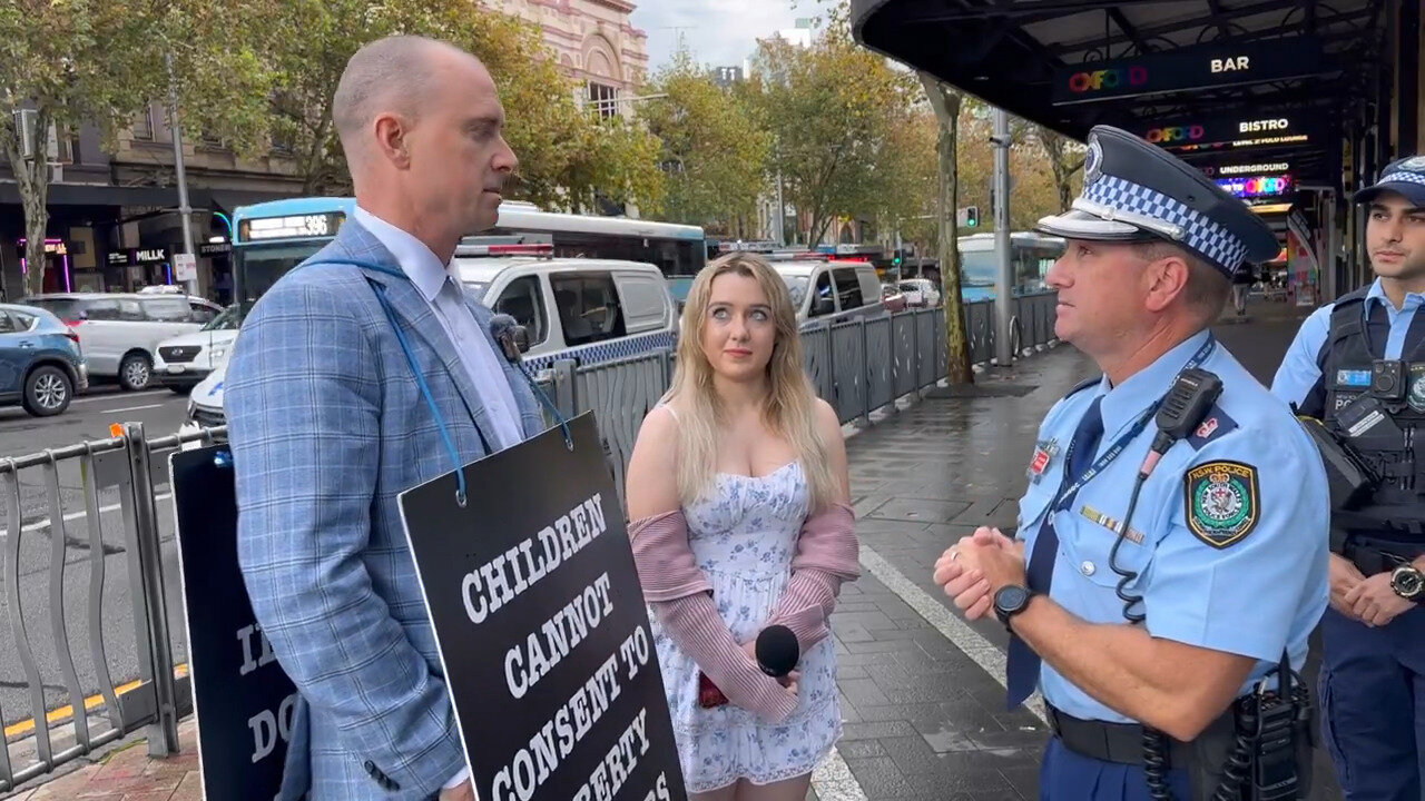 'Public Assembly': Watch Police Harass Billboard Chris, Anna McGovern For Wearing A Sign In Public