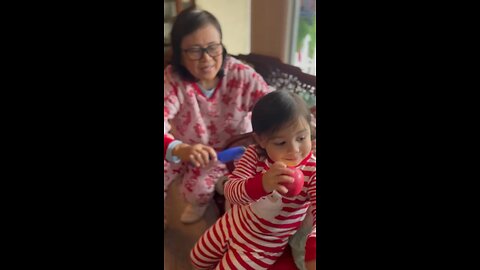 Grandma brushing my hair while eating apple