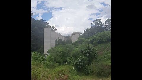 ANDANDO AO LADO DO ESQUELETO DO RODOANEL NORTE TRILHA CERCADA DE MATO E MORADIAS PRÓXIMAS