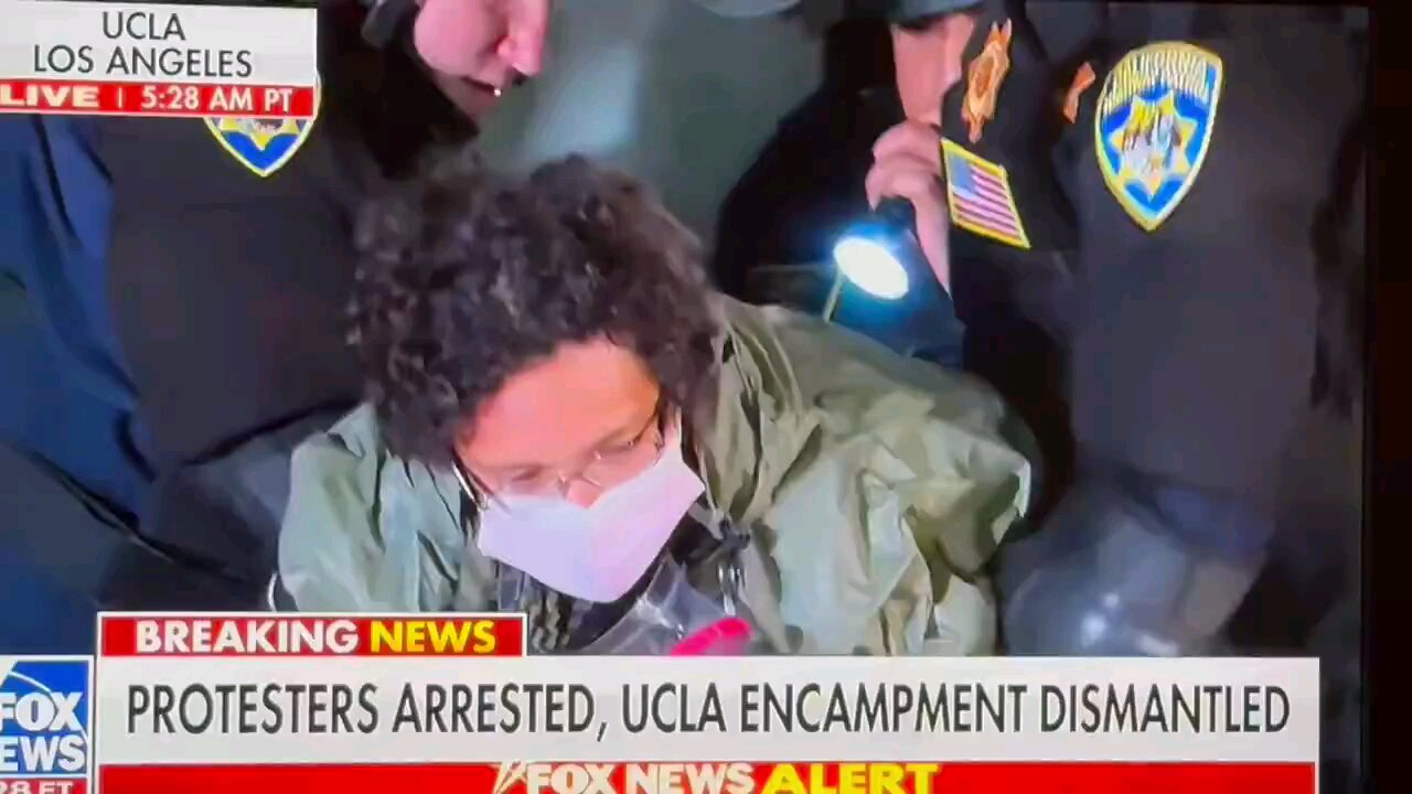 Police unmask protestors in front of the cameras.