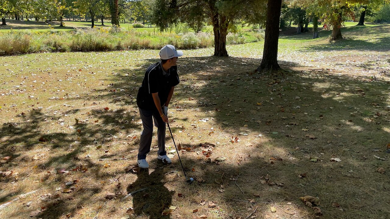 Golfer shanks a ball to the other fairway..