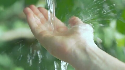 slow motion of clear water streaming on a human hand taking care about environment SBV 314192412 HD