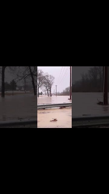 Flooded road over river bridge. Driving over through the water