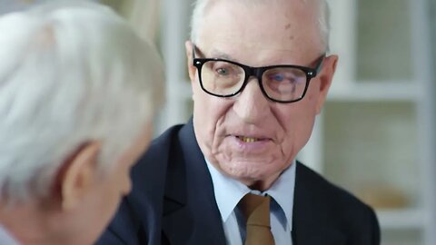 tilt up of serious senior businessman in suit and glasses discussing work with his SBV 325297120 HD