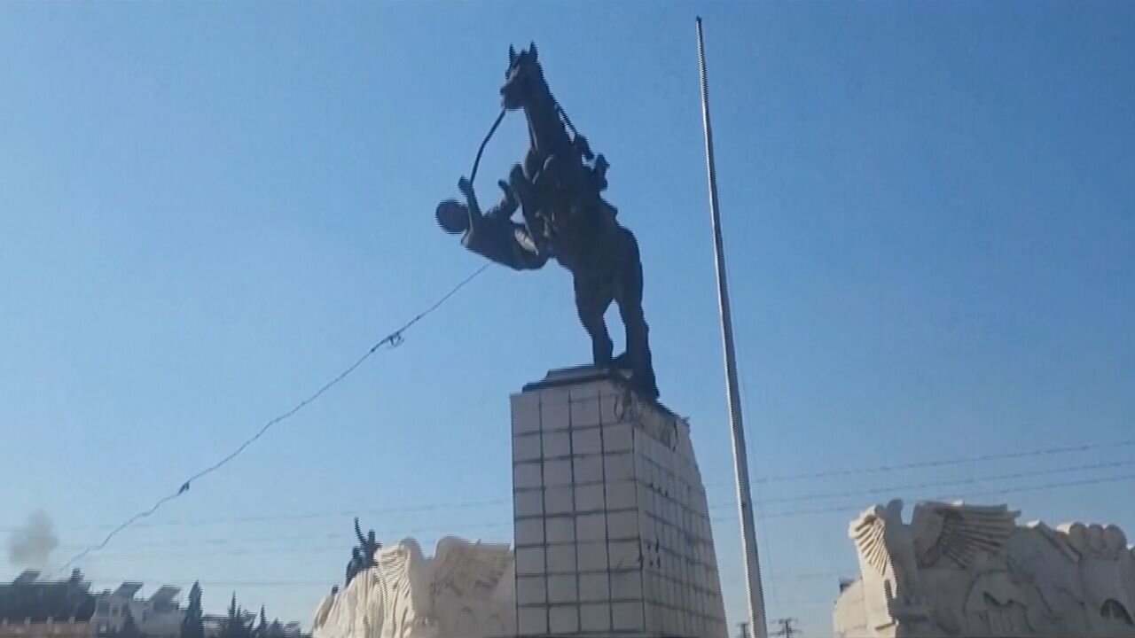 Insurgents in Syria topple a statue of President Assad's brother in Aleppo