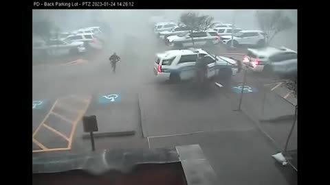 Surveillance footage shows police officer getting K9 to safety during tornado