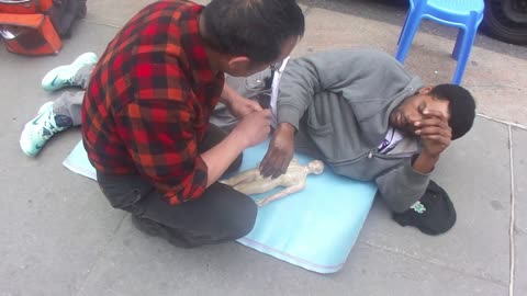 Luodong Massages Black Man On Sidewalk