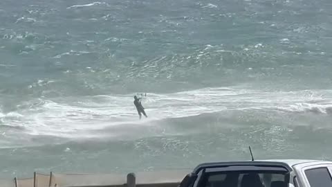 I've got a floaty plank and a big piece of cloth, it's crazy windy and huge waves…