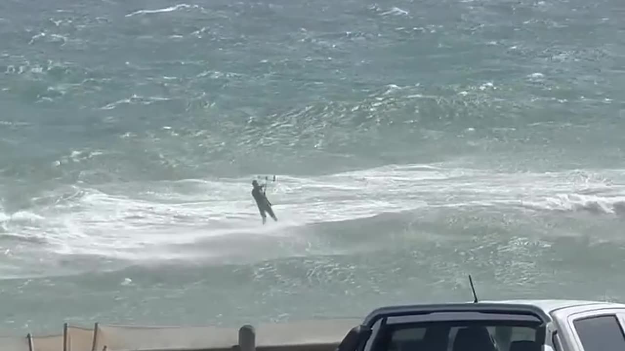 I've got a floaty plank and a big piece of cloth, it's crazy windy and huge waves…