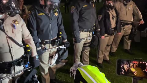 Pro-Palestinian protestor prays in front of police at UCLA