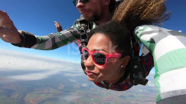 Beautiful Brazilian afro woman skydiving. Tandem jump with selfie image