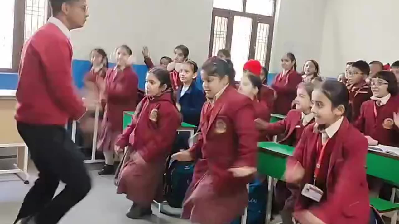 Teacher and students dancing in classroom