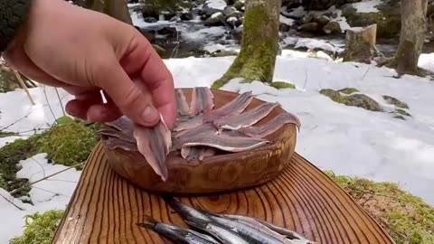 Cooking rice with anchovies on bricks in winter camping