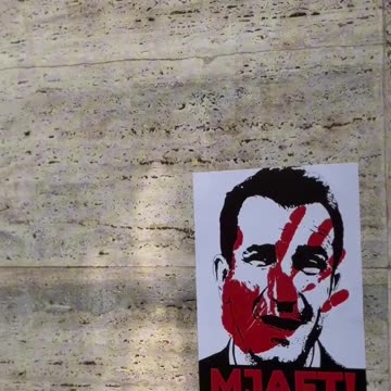 Klevis Balliu duke ngjitur postera neper Tirane