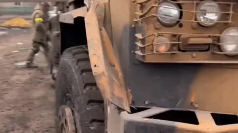 A Ukrainian serviceman demonstrates the consequences of Russian fire.