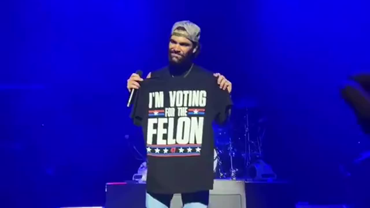 Dylan Scott holds up “I’m voting for the Felon” shirt at a concert & the crowd...