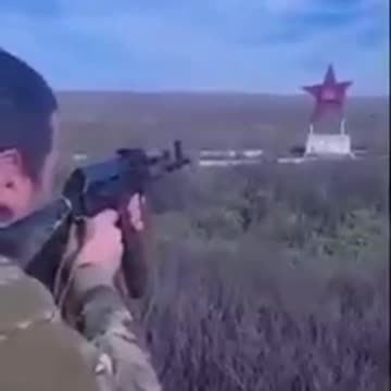 Ukrainian soldiers shoot at a monument for Soviet soldiers who died in WW2