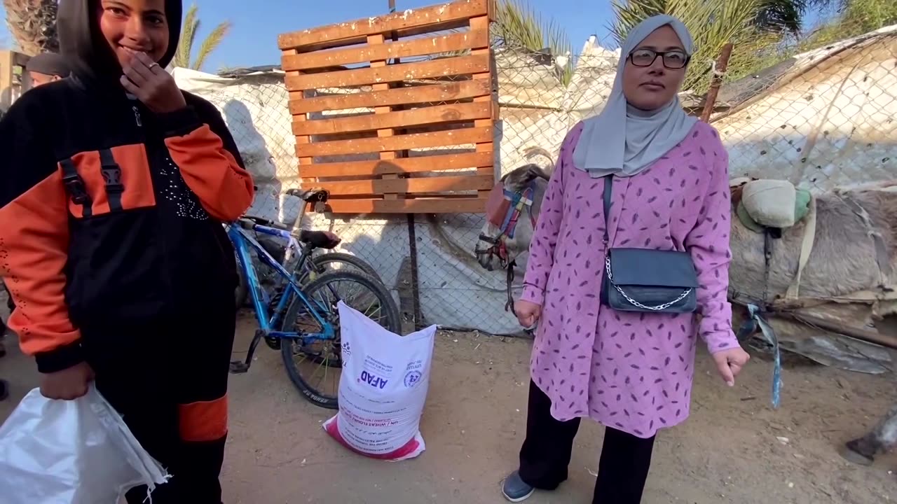 Palestinians receive flour at displacement camp in Khan Younis